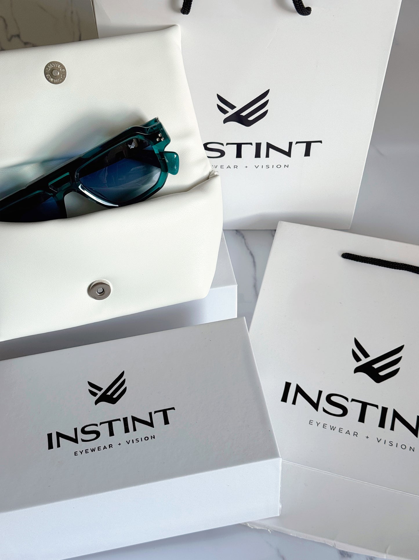 Confezione premium Instint Eyewear — astuccio rigido e panno in microfibra inclusi

