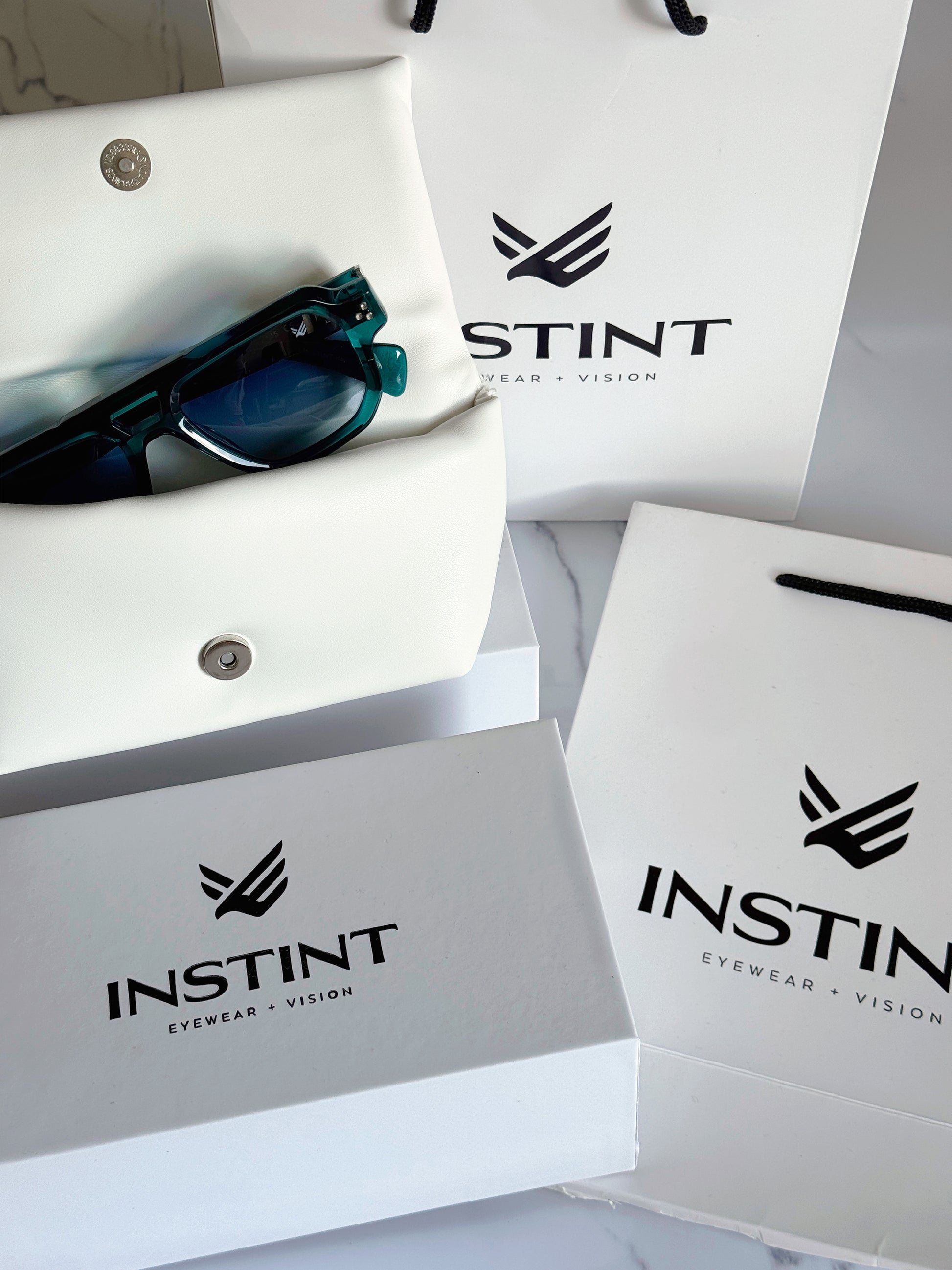 Confezione premium Instint Eyewear — astuccio rigido e panno in microfibra inclusi
